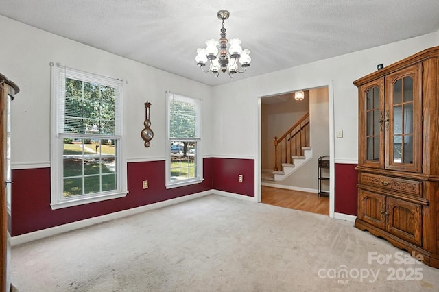 11100 Painted Tree Rd, Charlotte, NC 28226 - carpeted empty room with a chandelier and stairway