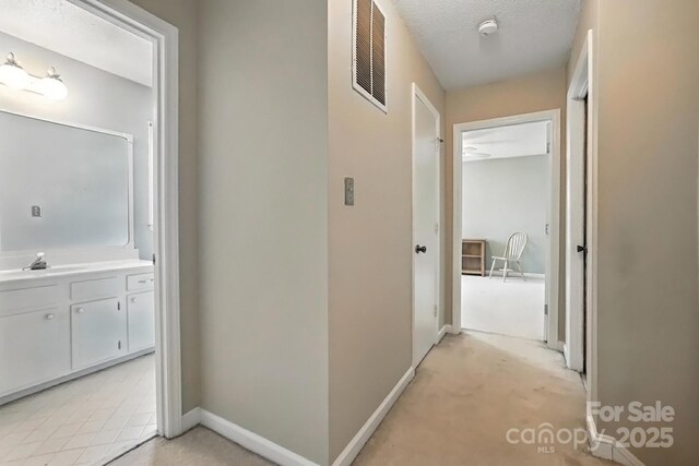 11100 Painted Tree Rd, Charlotte, NC 28226 - hallway featuring a textured ceiling and light carpet
