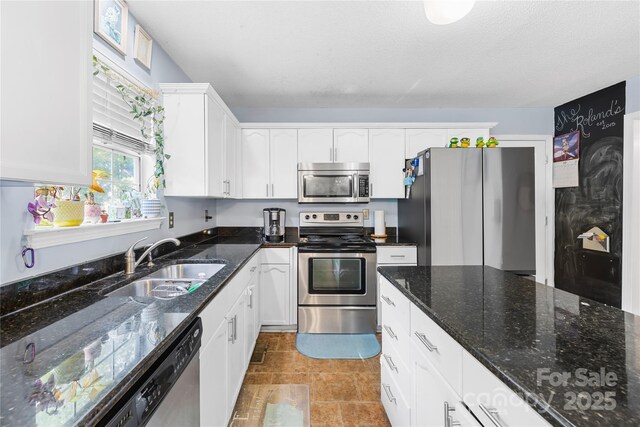 7410 Derby Meadows Ct, Charlotte, NC 28216 - kitchen with stainless steel appliances, white cabinets, and dark stone counters