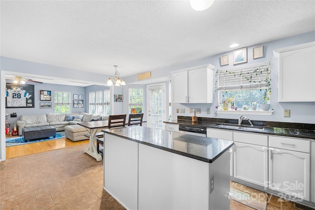 7410 Derby Meadows Ct, Charlotte, NC 28216 - kitchen with a textured ceiling, white cabinets, a chandelier, plenty of natural light, and a kitchen island