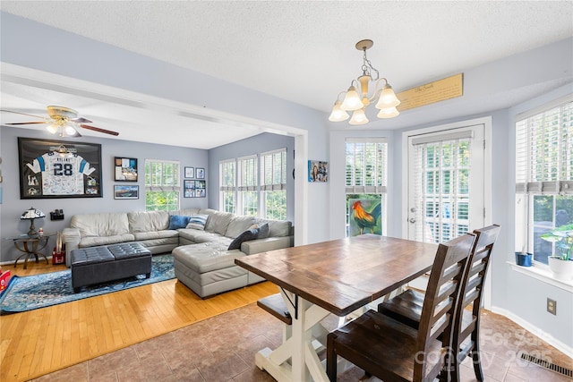 7410 Derby Meadows Ct, Charlotte, NC 28216 - tiled dining area with plenty of natural light, a chandelier, a ceiling fan, and a textured ceiling