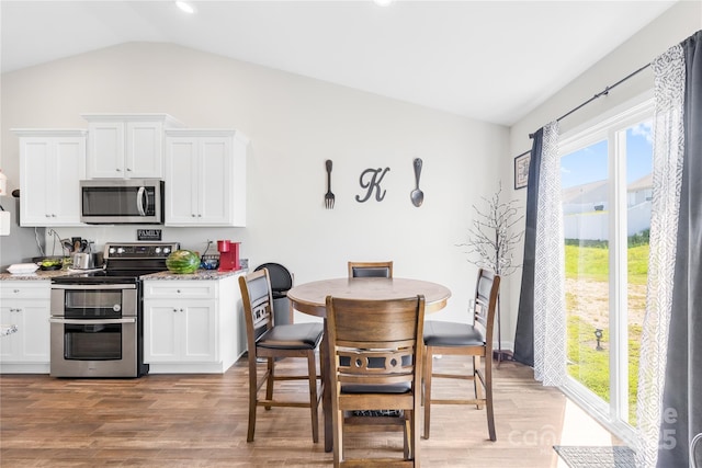 226 Caley St, Kings Mountain, NC 28086 - kitchen featuring appliances with stainless steel finishes, lofted ceiling, light wood-type flooring, white cabinetry, and light stone countertops
