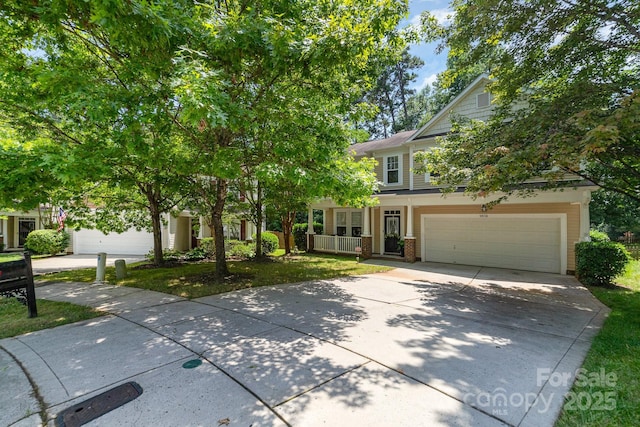 9836 Coatbridge Dr NW, Charlotte, NC 28269 - obstructed view of property with driveway, covered porch, and brick siding