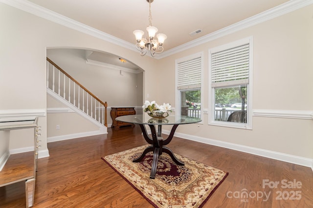 9836 Coatbridge Dr NW, Charlotte, NC 28269 - foyer featuring arched walkways, stairs, wood finished floors, crown molding, and a chandelier