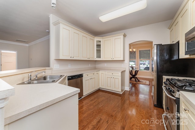 9836 Coatbridge Dr NW, Charlotte, NC 28269 - kitchen with appliances with stainless steel finishes, cream cabinets, arched walkways, wood finished floors, and crown molding
