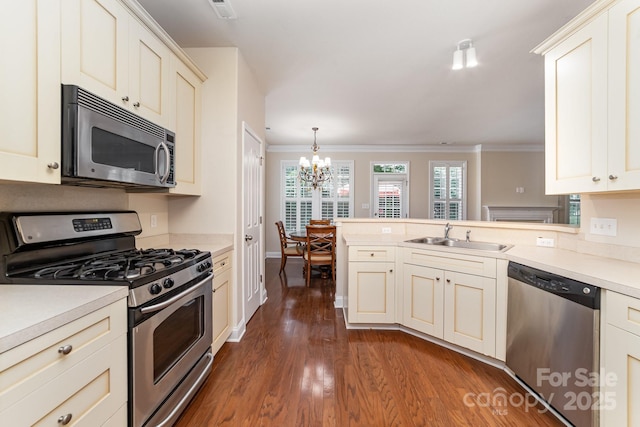 9836 Coatbridge Dr NW, Charlotte, NC 28269 - kitchen with appliances with stainless steel finishes, a chandelier, a peninsula, dark wood-style floors, and light countertops