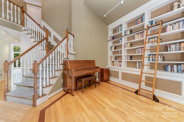 6225 Ash Cove Ln, Charlotte, NC 28269 - stairs featuring track lighting, wood finished floors, built in features, and a high ceiling
