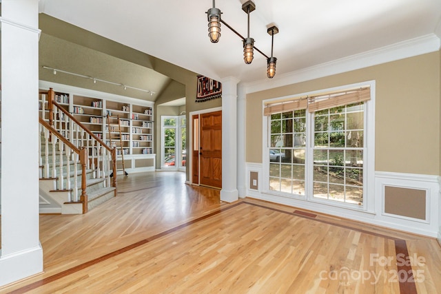 6225 Ash Cove Ln, Charlotte, NC 28269 - entryway featuring decorative columns, wood finished floors, vaulted ceiling, stairway, and wainscoting