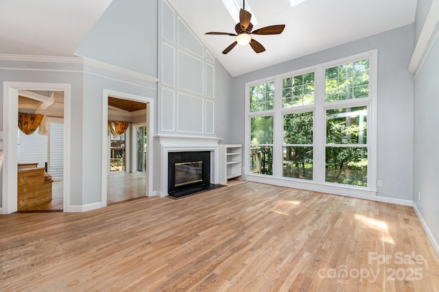6225 Ash Cove Ln, Charlotte, NC 28269 - unfurnished living room with light wood-style floors, ceiling fan, a fireplace, high vaulted ceiling, and crown molding