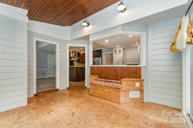 6225 Ash Cove Ln, Charlotte, NC 28269 - kitchen with wall chimney exhaust hood, stainless steel fridge, wooden ceiling, and wood walls