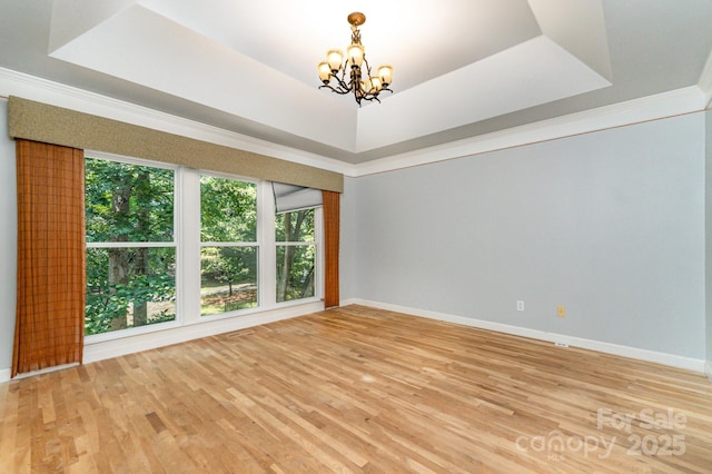 6225 Ash Cove Ln, Charlotte, NC 28269 - spare room featuring a chandelier, wood finished floors, a tray ceiling, and crown molding