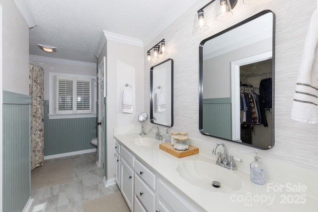 1631 Amanda Ln, Rock Hill, SC 29730 - bathroom featuring crown molding, double vanity, marble look tile flooring, a wainscoted wall, and a textured ceiling