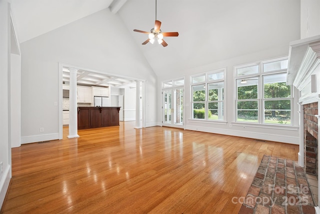 20308 Ridgebrook Ln, Locust, NC 28097 - unfurnished living room with high vaulted ceiling, decorative columns, a fireplace, a ceiling fan, and light wood-style floors