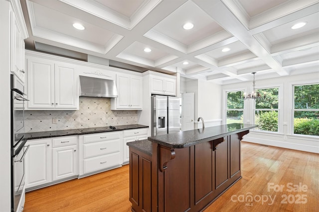 20308 Ridgebrook Ln, Locust, NC 28097 - kitchen with appliances with stainless steel finishes, wall chimney range hood, light wood-type flooring, white cabinets, and beam ceiling