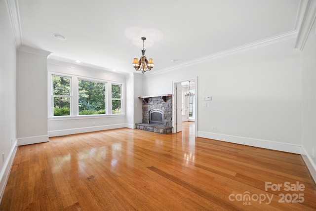 20308 Ridgebrook Ln, Locust, NC 28097 - unfurnished living room featuring a chandelier, ornamental molding, wood finished floors, and a stone fireplace