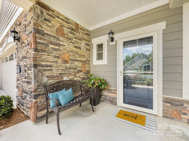 1313 Haywood Park Dr Unit 11, Waxhaw, NC 28173 - view of exterior entry featuring stone siding, a porch, and a garage