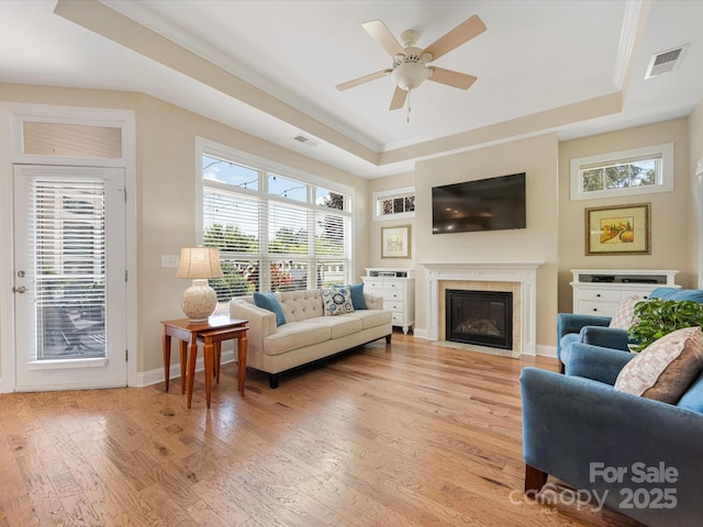 1313 Haywood Park Dr Unit 11, Waxhaw, NC 28173 - living room with a tray ceiling, ornamental molding, light wood-type flooring, a ceiling fan, and a fireplace with flush hearth