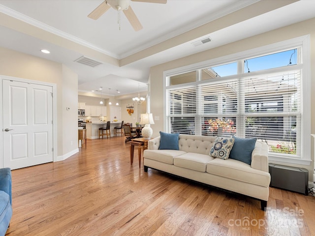 1313 Haywood Park Dr Unit 11, Waxhaw, NC 28173 - living room featuring crown molding, light wood finished floors, ceiling fan, plenty of natural light, and a chandelier