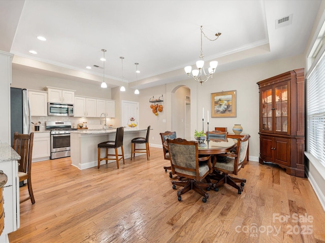 1313 Haywood Park Dr Unit 11, Waxhaw, NC 28173 - dining space featuring arched walkways, a raised ceiling, light wood finished floors, recessed lighting, and plenty of natural light