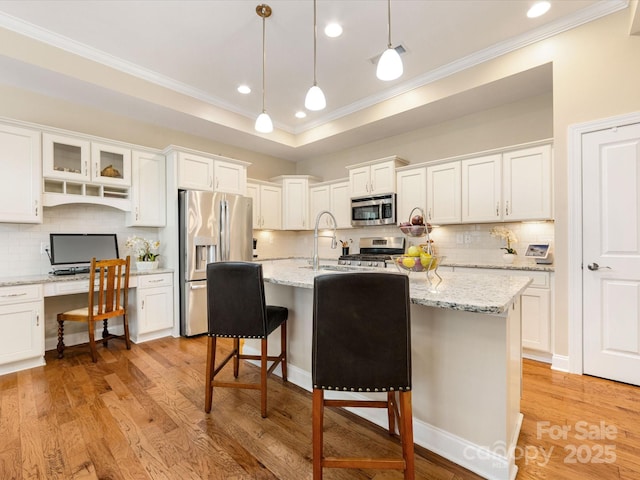 1313 Haywood Park Dr Unit 11, Waxhaw, NC 28173 - kitchen with ornamental molding, stainless steel appliances, white cabinets, built in study area, and backsplash