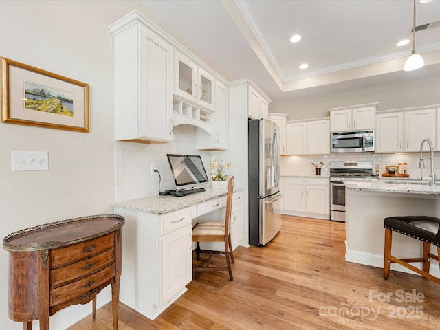 1313 Haywood Park Dr Unit 11, Waxhaw, NC 28173 - kitchen featuring a kitchen breakfast bar, crown molding, stainless steel appliances, tasteful backsplash, and white cabinetry