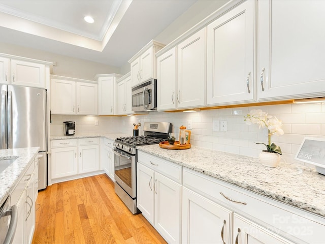 1313 Haywood Park Dr Unit 11, Waxhaw, NC 28173 - kitchen with appliances with stainless steel finishes, light wood-style flooring, white cabinets, backsplash, and recessed lighting