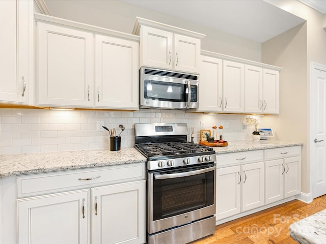 1313 Haywood Park Dr Unit 11, Waxhaw, NC 28173 - kitchen with stainless steel appliances, light wood-type flooring, white cabinets, and tasteful backsplash