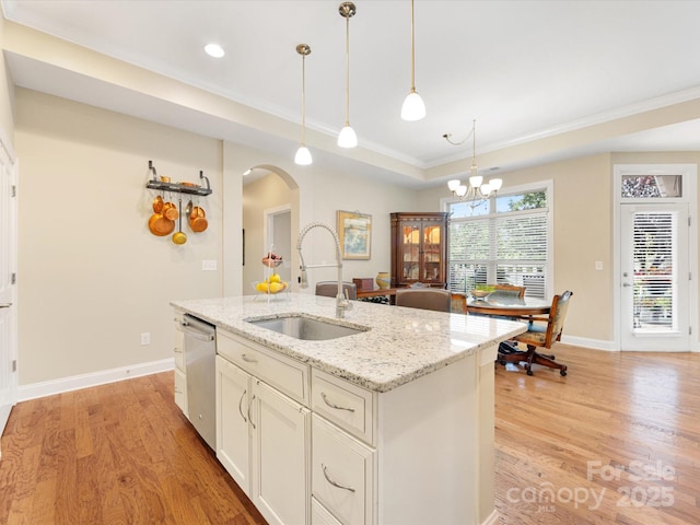 1313 Haywood Park Dr Unit 11, Waxhaw, NC 28173 - kitchen featuring arched walkways, ornamental molding, light wood finished floors, a raised ceiling, and hanging light fixtures