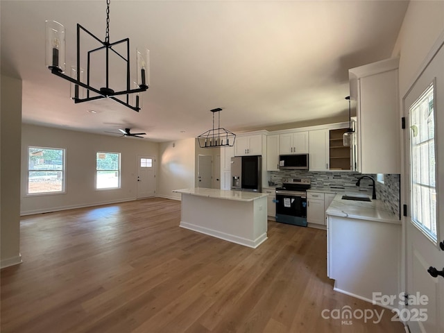 613 3rd Street Pl SW, Conover, NC 28613 - kitchen featuring stainless steel appliances, open floor plan, light wood-type flooring, a center island, and tasteful backsplash