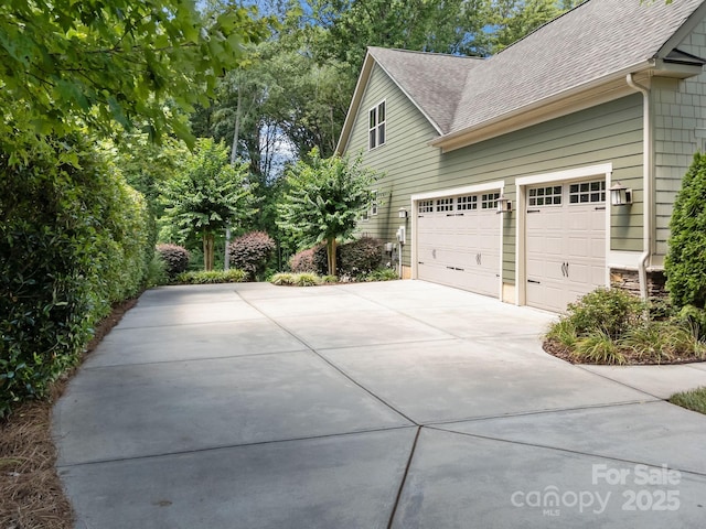 113 Chaska Loop, Troutman, NC 28166 - view of side of home with driveway, roof with shingles, and a garage