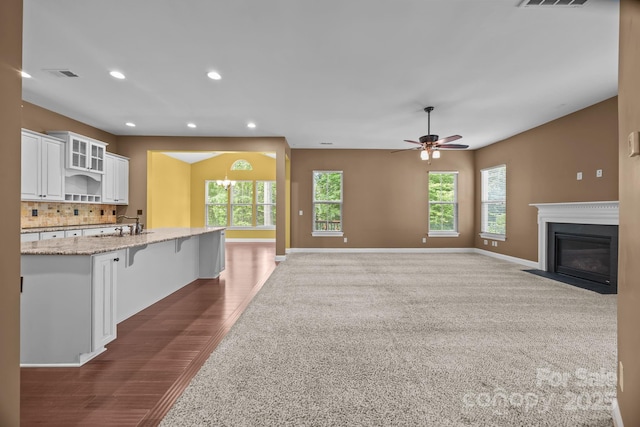 113 Chaska Loop, Troutman, NC 28166 - kitchen with white cabinets, light stone countertops, recessed lighting, decorative backsplash, and a fireplace with flush hearth