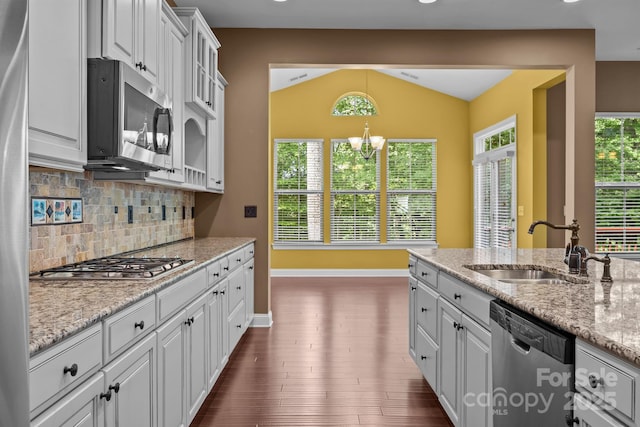 113 Chaska Loop, Troutman, NC 28166 - kitchen with appliances with stainless steel finishes, backsplash, lofted ceiling, white cabinetry, and light stone counters