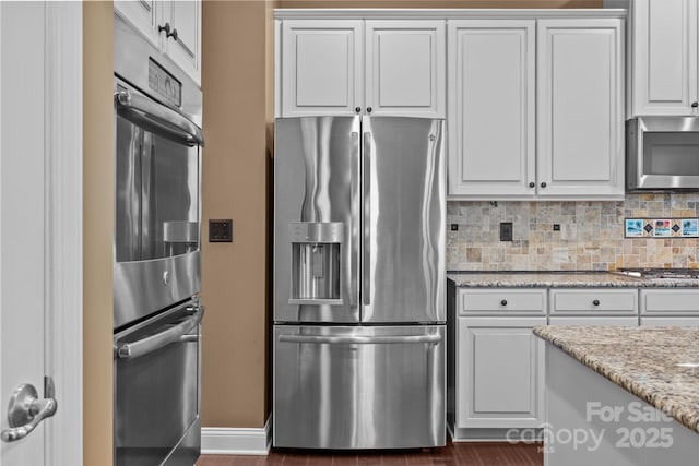 113 Chaska Loop, Troutman, NC 28166 - kitchen featuring appliances with stainless steel finishes, backsplash, white cabinets, and light stone countertops