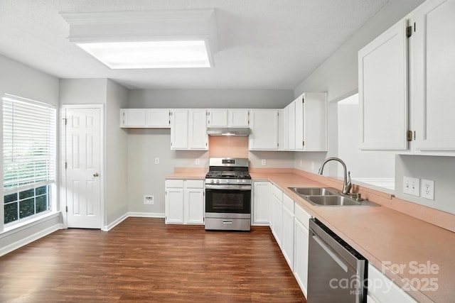 247 Aylesbury Ln, Indian Trail, NC 28079 - kitchen featuring appliances with stainless steel finishes, under cabinet range hood, dark wood-style floors, light countertops, and white cabinetry
