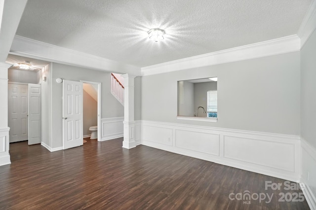 247 Aylesbury Ln, Indian Trail, NC 28079 - unfurnished room featuring a textured ceiling, ornamental molding, dark wood-style flooring, stairs, and a wainscoted wall