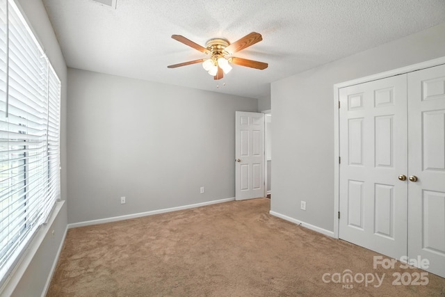 247 Aylesbury Ln, Indian Trail, NC 28079 - unfurnished bedroom featuring carpet, a textured ceiling, a closet, and a ceiling fan