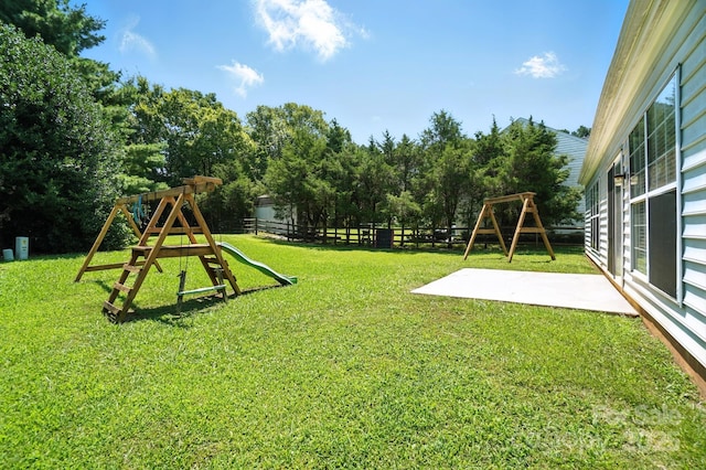 247 Aylesbury Ln, Indian Trail, NC 28079 - fenced backyard with a playground, a patio area, and view of scattered trees