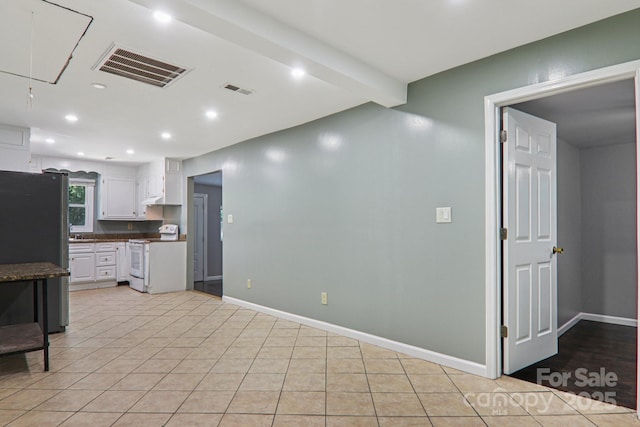 1416 Roy Dula Pl SW, Lenoir, NC 28645 - kitchen with electric range, freestanding refrigerator, dark countertops, white cabinetry, and light tile patterned flooring