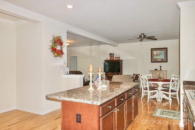 485 Calloway Rd, Lowgap, NC 27024 - kitchen with light wood finished floors, a ceiling fan, crown molding, a kitchen island, and open floor plan