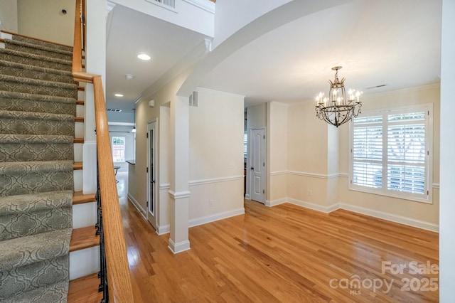 19421 Beaufain St, Cornelius, NC 28031 - entryway featuring ornamental molding, stairs, light wood finished floors, arched walkways, and a chandelier