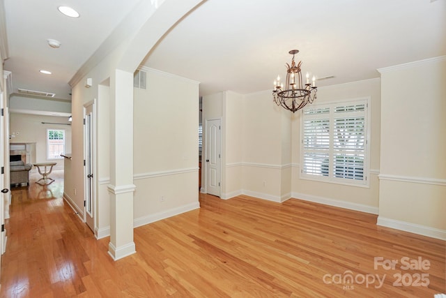 19421 Beaufain St, Cornelius, NC 28031 - empty room with light wood-type flooring, a smoke detector, a chandelier, arched walkways, and ornamental molding