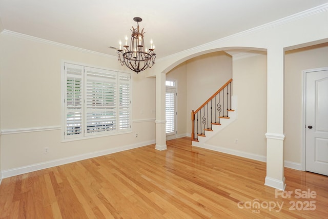19421 Beaufain St, Cornelius, NC 28031 - entryway featuring light wood-type flooring, crown molding, a chandelier, stairway, and arched walkways