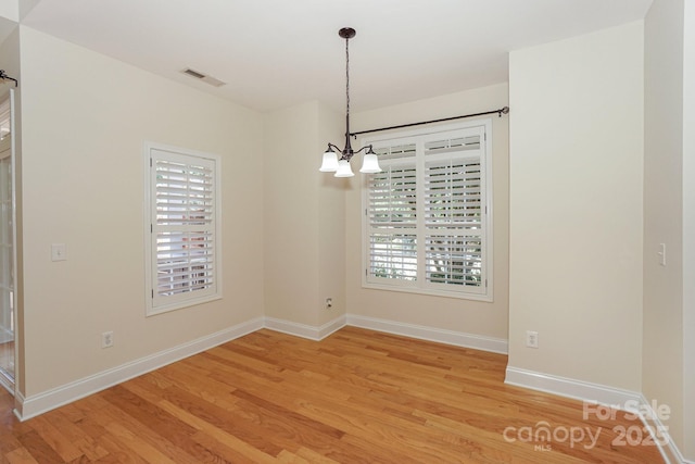 19421 Beaufain St, Cornelius, NC 28031 - unfurnished room featuring a chandelier, light wood-type flooring, and healthy amount of natural light