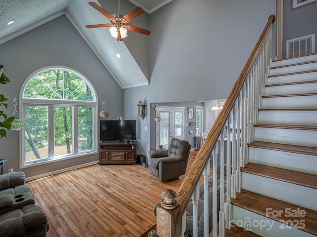 7376 NC-181 Hwy, Morganton, NC 28655 - living room with high vaulted ceiling, wood finished floors, a ceiling fan, stairs, and plenty of natural light