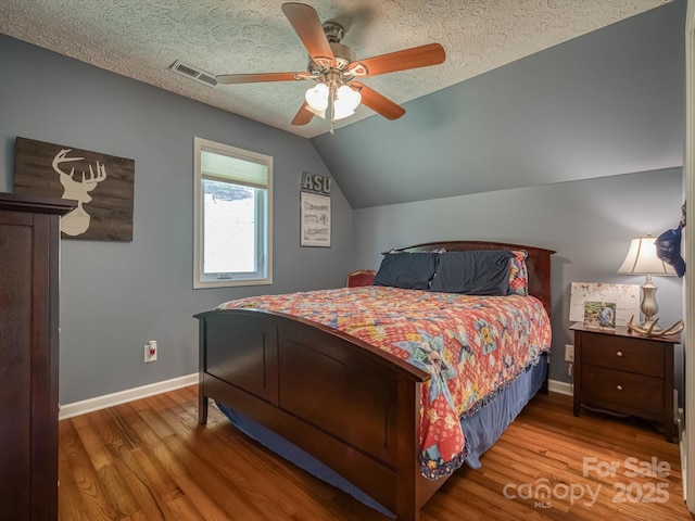 7376 NC-181 Hwy, Morganton, NC 28655 - bedroom with wood finished floors, lofted ceiling, ceiling fan, and a textured ceiling