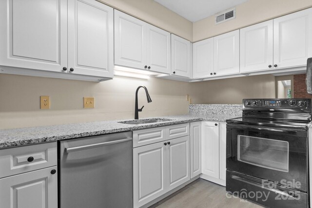 2705 N Center St Unit 76, Hickory, NC 28601 - kitchen featuring black electric range, dishwasher, white cabinetry, light stone counters, and light wood finished floors
