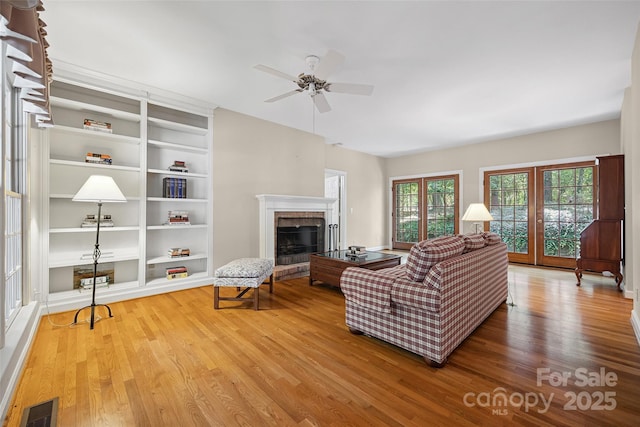 12 Woodvine Ln, Lake Wylie, SC 29710 - living room with wood finished floors, a fireplace, built in shelves, and a ceiling fan