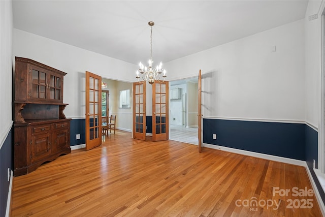 12 Woodvine Ln, Lake Wylie, SC 29710 - unfurnished dining area with french doors, light wood-style flooring, and a chandelier