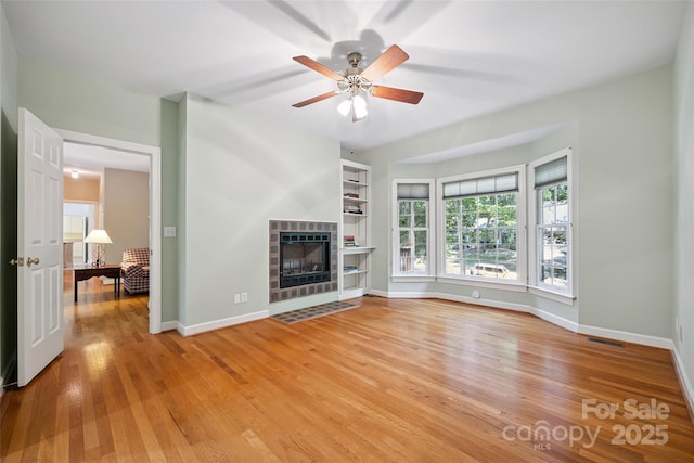 12 Woodvine Ln, Lake Wylie, SC 29710 - unfurnished living room featuring light wood-style flooring, a ceiling fan, and a tile fireplace