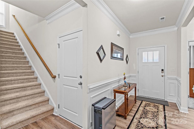 117 Cup Chase Dr, Mooresville, NC 28115 - foyer entrance with ornamental molding, light wood-style flooring, stairway, and a wainscoted wall